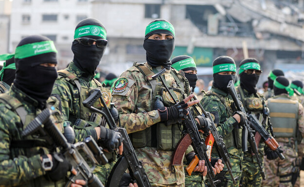 מחבלי חמאס במהלך העברת התצפיתניות לידי הצלב האדום (צילום: reuters)