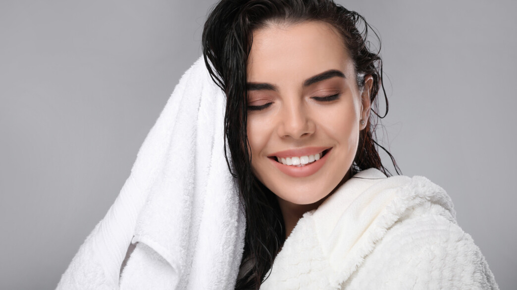 אישה יוצאת מהמקלחת אחרי חפיפה - שמפו ללא סולפטים של פינוק