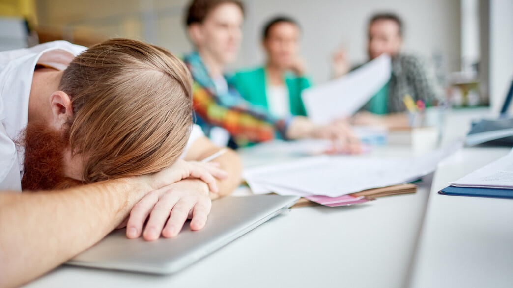 עובד מודאג עם ראש בין הידיים