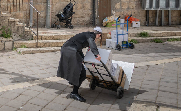 חרדי לוקח מוצרי מזון שקיבל במסגרת קמחא דפסחא בשכונת מאה שערים חרדי לוקח מוצרי מזון שקיבל במסגרת קמחא דפסחא בשכונת מאה שערים
