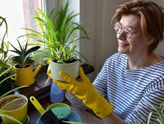 אישה בשנות ה-50 לחייה עם עציצים