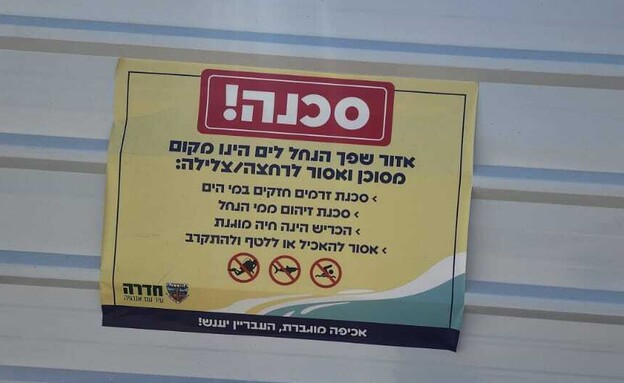 שלט אזהרה בכניסה לאזור החוף בנחל חדרה (צילום: N12)