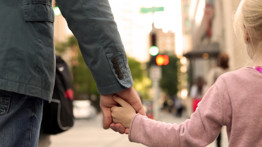 גבר מחזיק יד של ילדה