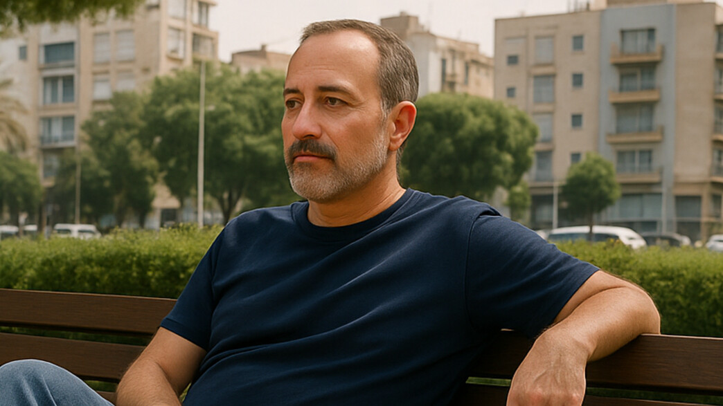 גבר יושב על ספסל בפארק גבר יושב על ספסל בפארק