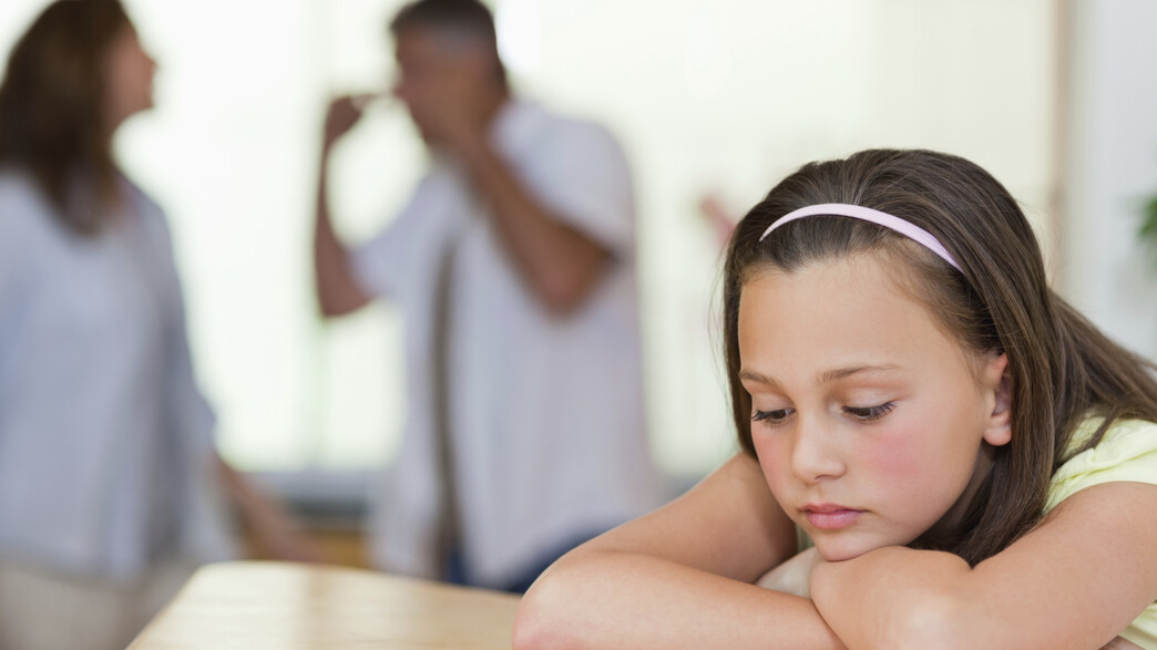 ילד עצובה על רקע הורים רבים