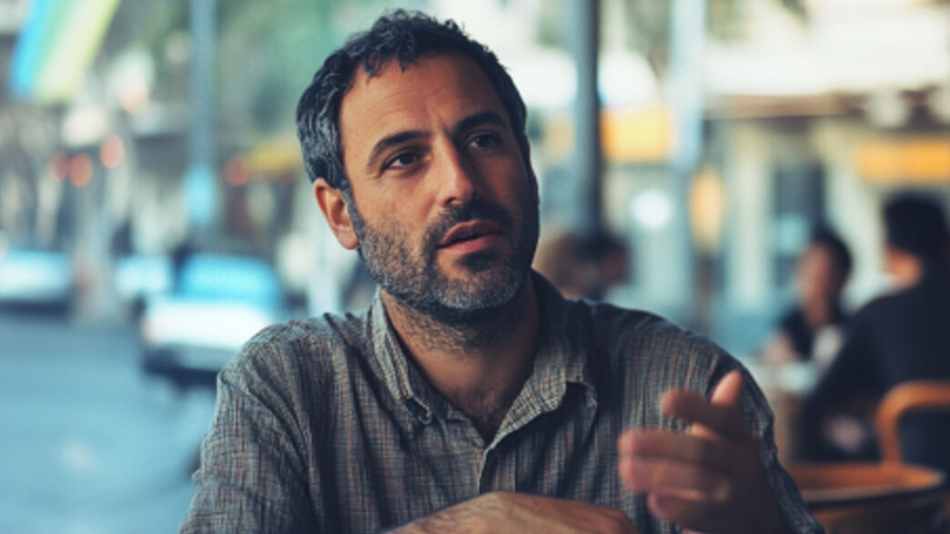 גבר יושב בבית קפה ומדבר