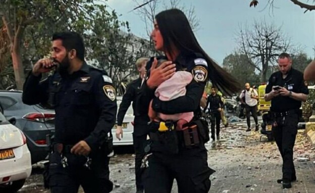 שוטרת חילצה תינוקת מבית שנפגע (צילום: דביר מור)
