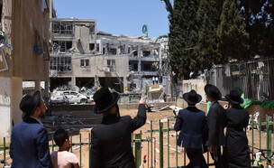 תושבי בני ברק צופים באתר נפילת הטיל האיראני, 16.6.25 (צילום: גיל יערי, פלאש 90)