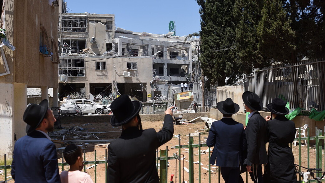 תושבי בני ברק צופים באתר נפילת הטיל האיראני, 16.6.25 (צילום: גיל יערי, פלאש 90)