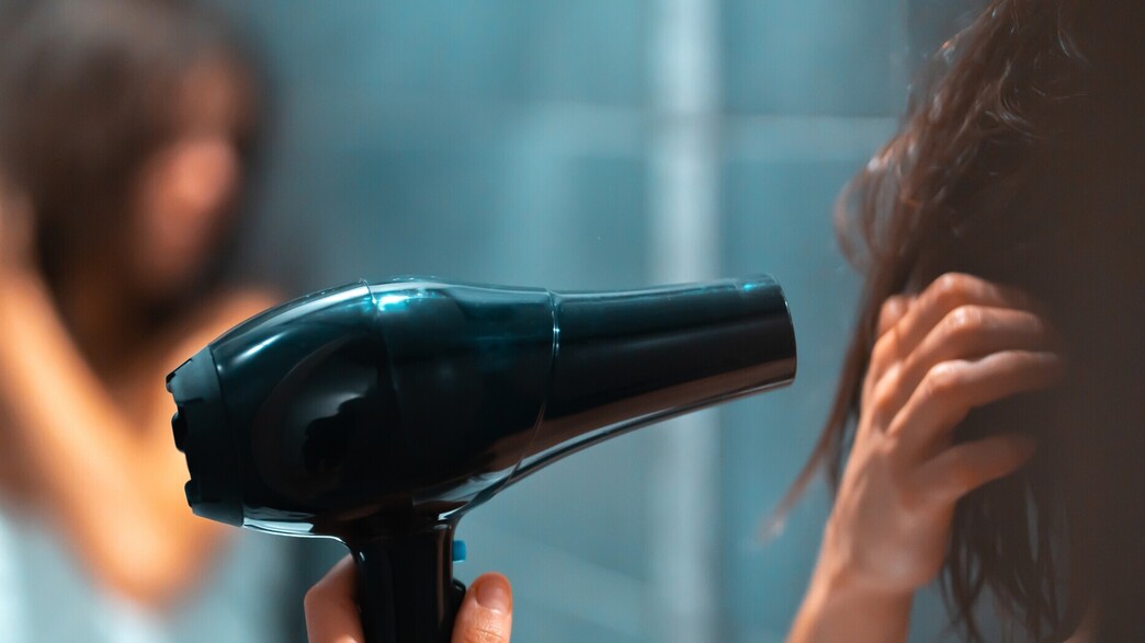 אישה מייבשת שיער