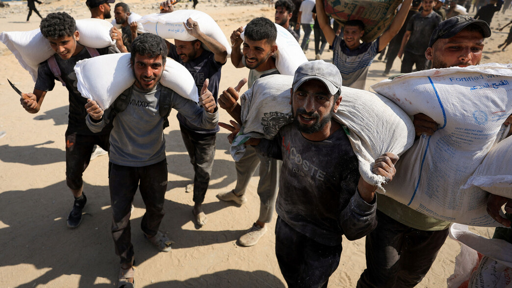 אזרחים עזתים סוחבים סיוע הומניטרי אזרחים עזתים סוחבים סיוע הומניטרי