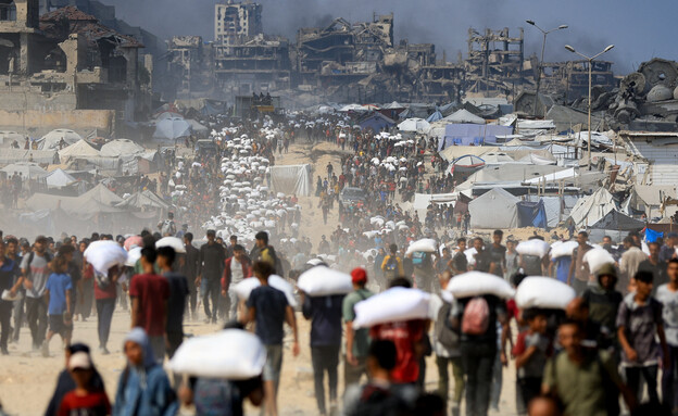 אזרחים עזתים סוחבים סיוע הומניטרי (צילום: Reuters)