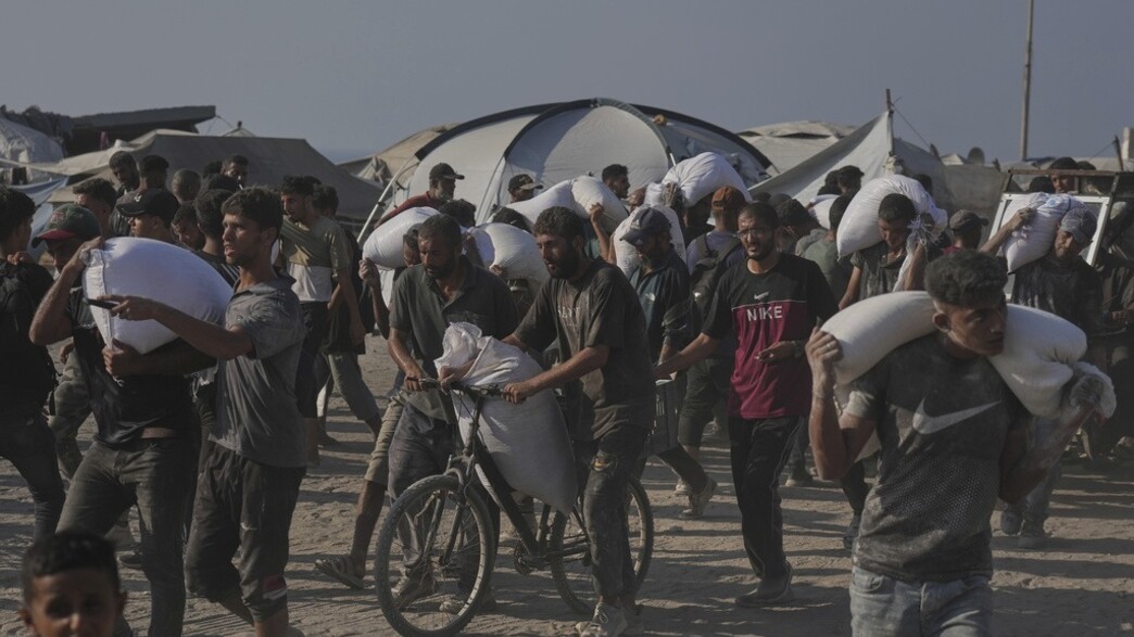 פלסטינים פורקים שקים של סיוע הומניטרי בעיר עזה פלסטינים פורקים שקים של סיוע הומניטרי בעיר עזה