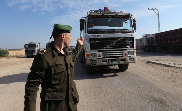 איש מנגנוני הביטחון הפלסטיניים מכוון משאית סחורה