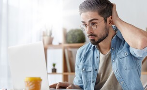 גבר עובד על מחשב נייד, חושב, מגרד בראש (צילום: Cast Of Thousands, shutterstock)