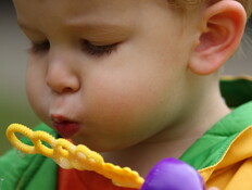 פעוט נושף על צעצוע של בועות סבון פעוט נושף על צעצוע של בועות סבון