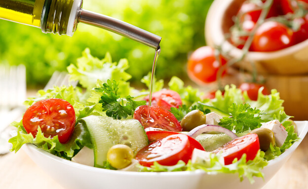 שמן זית נמזג על סלט ירקות (צילום: Nitr, shutterstock)