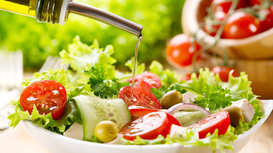 שמן זית נמזג על סלט ירקות