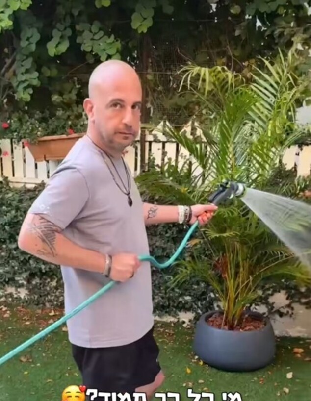 אורי זך, הבעל של מירי מסיקה, משקה את הגינה