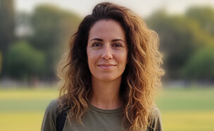 אישה עומדת באתר תיירותי (AI: mako)