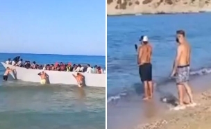 תיירים דוחפים סירת מהגרים יוון  (צילום: לפי סעיף 27א' לחוק זכויות יוצרים)