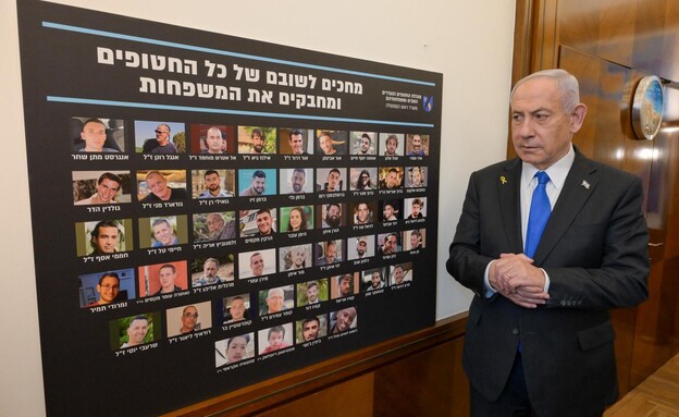 ראש הממשלה מצטלם ליד תמונותיהם של כלל החטופים העתי ראש הממשלה מצטלם ליד תמונותיהם של כלל החטופים העתי