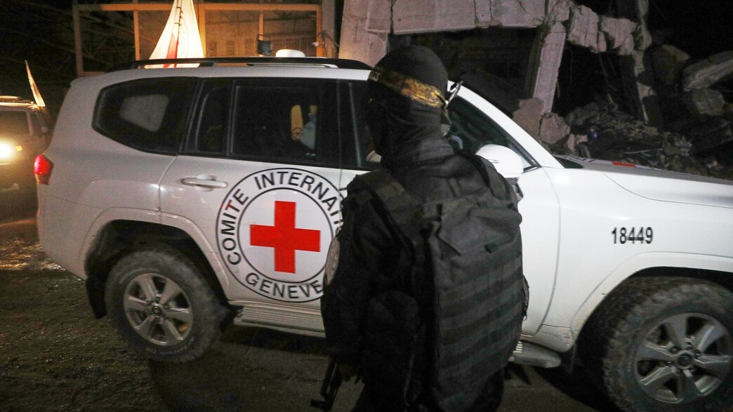 מחבלי חמאס בנקודת העברת החללים החטופים לצלב האדום