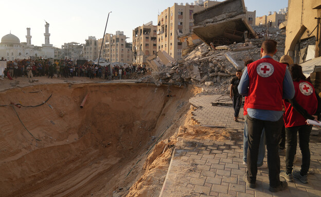 כוחות חמאס והצלב האדום בחיפש אחר גופות חטופים חללי (צילום: AP)