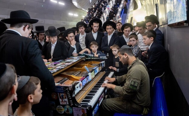 חייל מנגן לחרדים שבדרכם להפגנה חייל מנגן לחרדים שבדרכם להפגנה