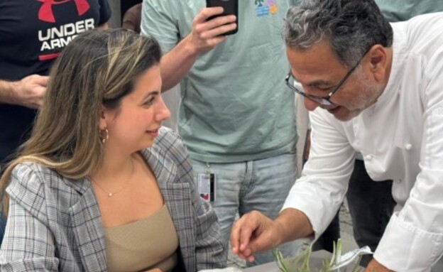 שף חיים כהן מסביר לאחת מיוצרות הפרומפטים איך תרגם 