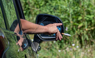 השלכת סיגריה בכביש (צילום: Photo by FREDERIC MOREAU/Hans Lucas/AFP via Getty Images)