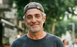 גבר עומד ברחוב מסתכל למצלמה (AI: mako)