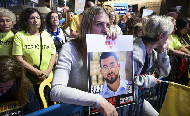 מפגינים בכיכר החטופים עם תמונתו של רן גואילי