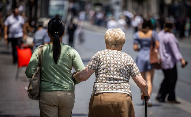 קשישה עם מטפלת ברחוב קשישה עם מטפלת ברחוב