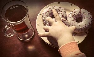 ילדה אוכלת סופגניות (צילום: Shutterstock)