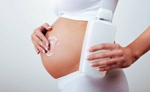 אישה בהריון מורחת קרם (צילום: istockphoto)