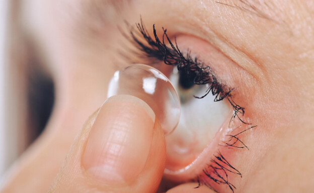 אישה מרכיבה עדשות מגע (צילום: Dmytro Khlystun, Shutterstock)