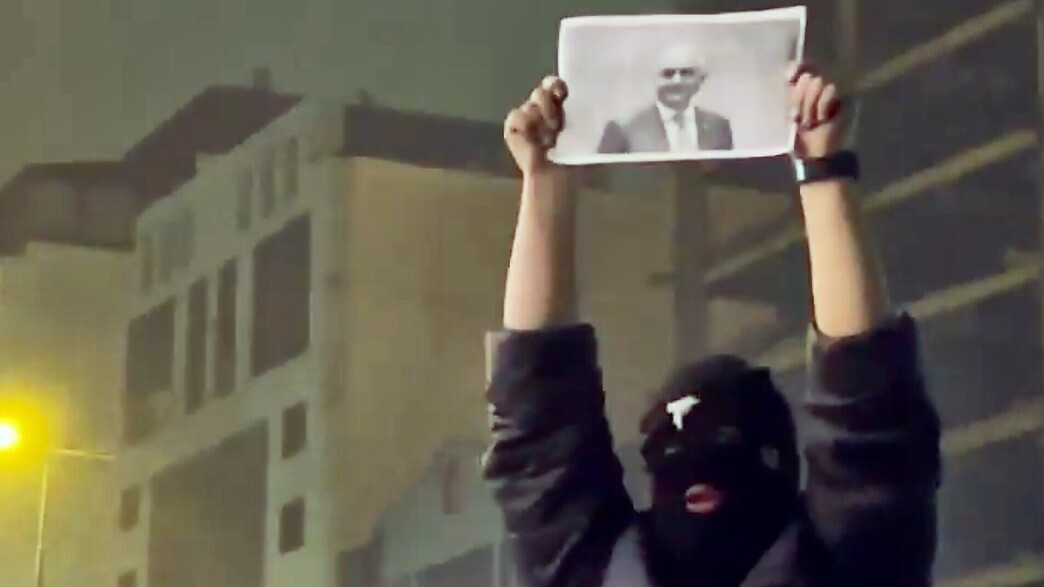 מפגין איראני מחזיק בתמונה של רזא פהלווי בהפגנות