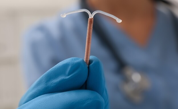רופאה מחזיקה התקן נחושת תוך רחמי