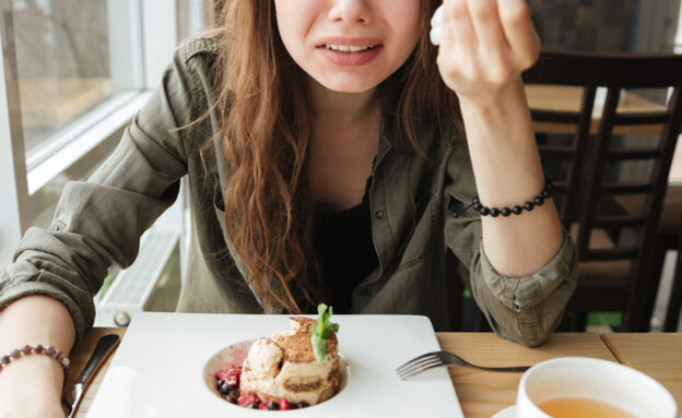 אוכלת עוגה ובוכה