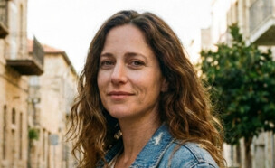 אישה צעירה עומדת ברחוב ומסתכלת למצלמה (AI: mako)