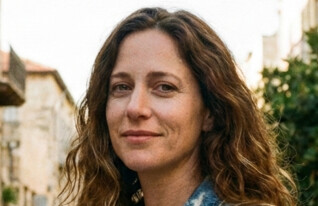 אישה צעירה עומדת ברחוב ומסתכלת למצלמה (AI: mako)