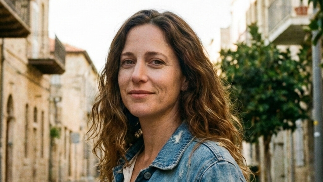 אישה צעירה עומדת ברחוב ומסתכלת למצלמה אישה צעירה עומדת ברחוב ומסתכלת למצלמה