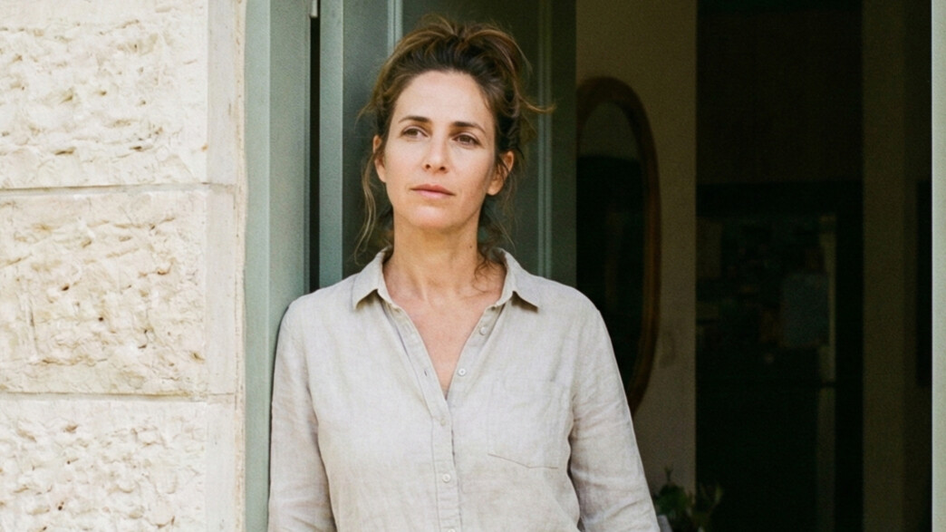 אישה עומדת בפתח הבית