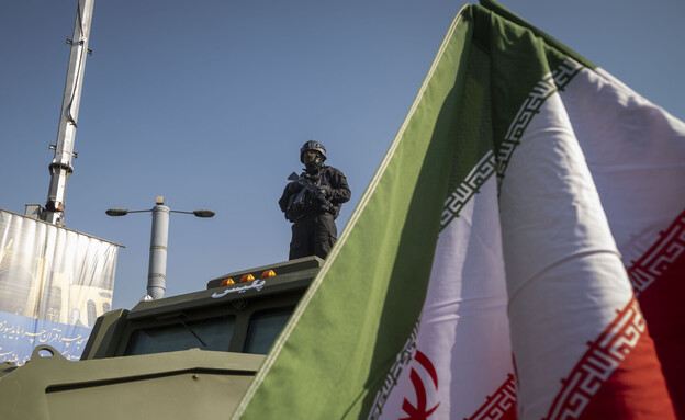 שוטר באיראן עומד על רכב משוריין בעצרת תמיכה במשטר (צילום: Getty images)