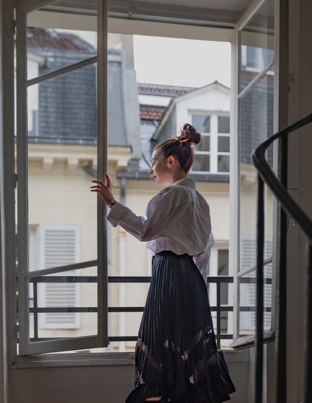 פותחת חלון, ליד חלון פתוח