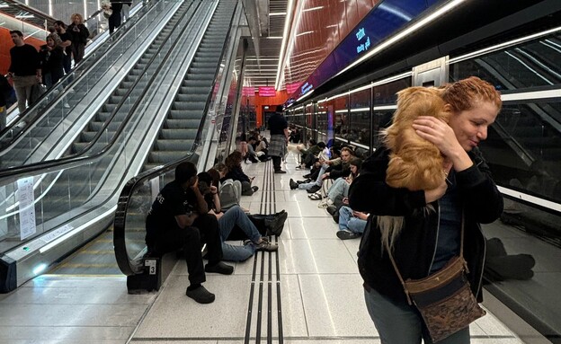 אנשים מתגוננים מהאזעקות ברכבת הקלה