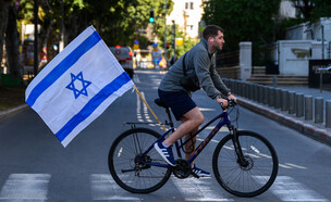רוכב אופניים בתל אביב עם דגל ישראל (צילום: Alexi J. Rosenfeld / Stringer, Getty Images)