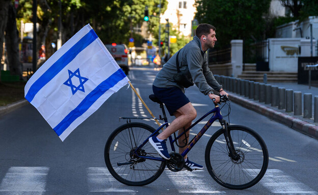 רוכב אופניים בתל אביב עם דגל ישראל