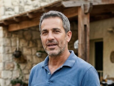 גבר עומד בחצר הבית שלו